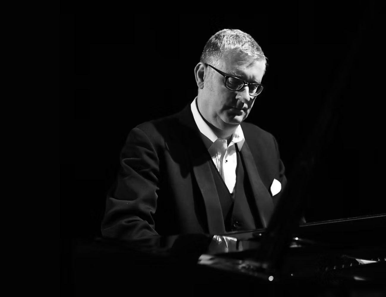 Black and white photograph of Chris Ingham at a piano